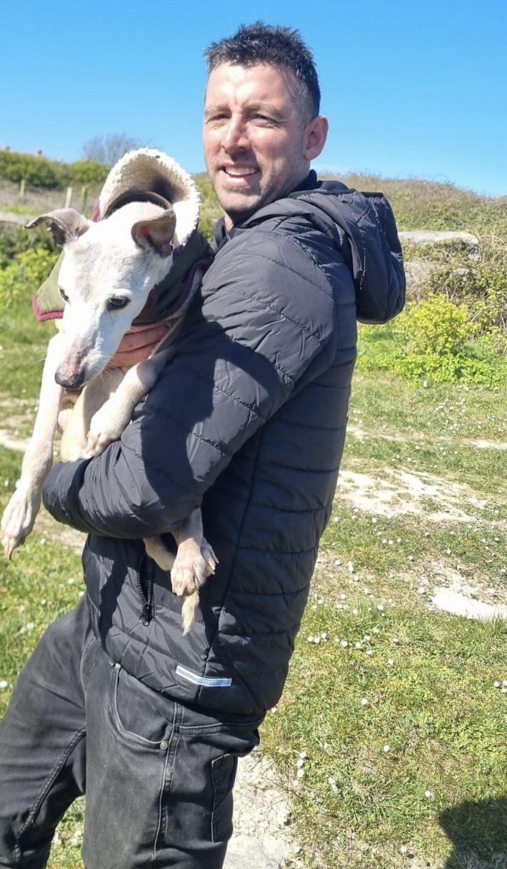 Dave Rimmer holding a rescued whippet